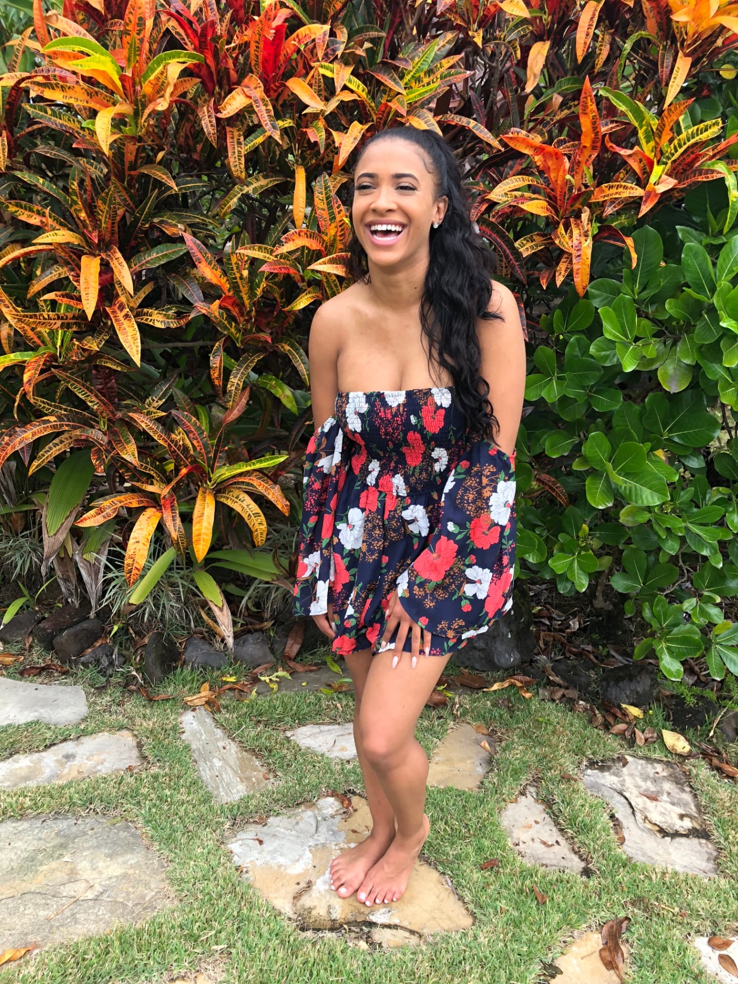 Heather Everett smiling outdoors in front of tropical foliage